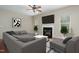 Cozy living room with hardwood floors, fireplace, gray sofa, and contemporary decor at 8409 Astwell Ct, Raleigh, NC 27615
