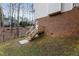 Backyard with a wooden staircase and partial view of the brick foundation, offering outdoor access at 905 Balmoral Dr, Cary, NC 27511