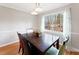 Bright dining room with a dark wood table and chairs and a large window at 905 Balmoral Dr, Cary, NC 27511