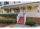 Inviting front porch with white railings, red steps, and hanging ferns at 905 Balmoral Dr, Cary, NC 27511