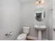 Powder room featuring a pedestal sink, toilet, and an oval mirror at 9221 Calabria Dr # 116, Raleigh, NC 27617