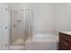 Bathroom featuring a soaking tub, tiled shower, and a light-colored tiled floor at 9221 Calabria Dr # 116, Raleigh, NC 27617
