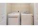 Convenient laundry room with side-by-side, modern white washer and dryer units at 9221 Calabria Dr # 116, Raleigh, NC 27617