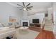 Bright living room boasts a fireplace, ceiling fan, and beautiful hardwood floors at 9221 Calabria Dr # 116, Raleigh, NC 27617