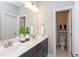 Well-lit bathroom featuring double sinks, a large mirror, and an adjacent toilet room at 9517 Wood River Dr, Zebulon, NC 27597