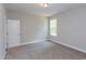 Cozy bedroom featuring neutral walls, carpet, window, and a door on the left at 9517 Wood River Dr, Zebulon, NC 27597