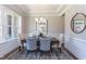 Elegant dining room featuring wainscoting, a modern chandelier, and ample natural light at 9517 Wood River Dr, Zebulon, NC 27597