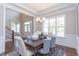 Elegant dining room featuring wainscoting, a modern chandelier, and ample natural light at 9517 Wood River Dr, Zebulon, NC 27597