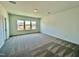 A carpeted bedroom has three windows that let in natural light and white walls at 100 N Stonemill Trl # Homesite 252, Wilson's Mills, NC 27520