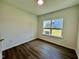 Bedroom with wood floors and natural light showcasing a view of the backyard at 100 N Stonemill Trl # Homesite 252, Wilson's Mills, NC 27520
