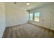 A carpeted bedroom with white walls has two windows that let in natural light at 100 N Stonemill Trl # Homesite 252, Wilson's Mills, NC 27520