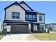 A beautiful two-story home with a 2-car garage, black trim, stone accents, and a well-manicured lawn at 100 N Stonemill Trl # Homesite 252, Wilson's Mills, NC 27520