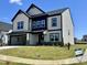 A beautiful two-story home with a 2-car garage, black trim, stone accents, and a well-manicured lawn at 100 N Stonemill Trl # Homesite 252, Wilson's Mills, NC 27520