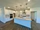 Modern white kitchen features quartz countertops, stainless appliances and pendant lighting at 100 N Stonemill Trl # Homesite 252, Wilson's Mills, NC 27520