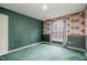 Bedroom with green carpet, patterned wallpaper and a bright window with natural light at 1122 Sally Drive Dr, Graham, NC 27253