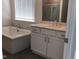 Bathroom showcasing a soaking tub and vanity with stone countertop at 1404 Malcus Ct # 56, Fuquay Varina, NC 27526