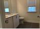 Bathroom featuring double sink, vanity, toilet and dark tile flooring at 1404 Malcus Ct # 56, Fuquay Varina, NC 27526
