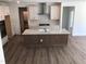 Bright kitchen features an island with stone countertops, a modern oven, and white cabinets for storage at 1404 Malcus Ct # 56, Fuquay Varina, NC 27526