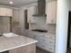 Modern kitchen features stainless vent hood, white cabinets, and stone countertops at 1404 Malcus Ct # 56, Fuquay Varina, NC 27526