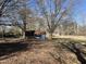 The backyard featuring mature trees, with fallen leaves creating a natural and serene setting at 1413 Bud Hawkins Rd, Dunn, NC 28334