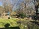 Lush backyard featuring green grass, mature trees, a playset, and a partially obscured chain-link fence at 1413 Bud Hawkins Rd, Dunn, NC 28334