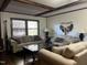 Comfortable living room featuring neutral furniture, wood beam ceilings, and large windows at 1413 Bud Hawkins Rd, Dunn, NC 28334