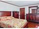 Well-lit main bedroom with wood furniture, complemented by floral bedding, offers a serene retreat at 1413 Bud Hawkins Rd, Dunn, NC 28334