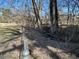 Trees, fence, and dry creekbed in a wooded area behind the house at 1516 Park Ln, Hillsborough, NC 27278