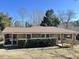 Charming brick home featuring a screened-in porch and accessible wooden ramp at 1516 Park Ln, Hillsborough, NC 27278