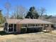 View of brick home exterior with screened-in porch and manicured bushes at 1516 Park Ln, Hillsborough, NC 27278