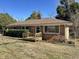 Brick home featuring a wooden deck, mature landscaping, and a well-maintained lawn at 1516 Park Ln, Hillsborough, NC 27278