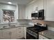 Modern kitchen with stainless steel appliances, granite countertops, and white cabinets at 1516 Park Ln, Hillsborough, NC 27278