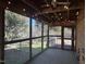 Enclosed sunroom with brick wall, carpet, ceiling fan, and windows overlooking the yard at 1516 Park Ln, Hillsborough, NC 27278