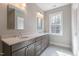 This bathroom features a double sink vanity with a stone countertop and a large window for natural light at 1721 Birdhaven Ln, Wendell, NC 27591