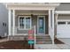 Inviting front porch with white railings, brick steps, and an attractive blue front door at 1721 Birdhaven Ln, Wendell, NC 27591