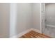 Neutral hallway leading to powder room with hardwood flooring and white trim at 1721 Birdhaven Ln, Wendell, NC 27591