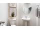 Charming powder room featuring modern fixtures, stylish artwork, and a decorative plant at 1910 Frost Dr, Haw River, NC 27258