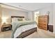 Well-lit bedroom featuring neutral tones and a wooden dresser near the door at 200 S Dawson St # 103, Raleigh, NC 27601