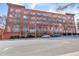 Exterior view of a multi-story brick building featuring large arched windows and small balconies under a bright sky at 200 S Dawson St # 103, Raleigh, NC 27601