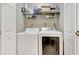 Functional laundry area with a white washer and dryer set, complemented by shelving for storage and linens at 200 S Dawson St # 103, Raleigh, NC 27601