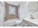 Updated bathroom featuring decorative tile accent wall, tub, and updated sink and fixtures at 210 Monk Rd, Durham, NC 27704