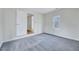 Carpeted bedroom featuring an open doorway leading to a walk in closet with a bright window at 210 Monk Rd, Durham, NC 27704