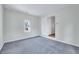 Carpeted bedroom with a window and a closet and open door to a storage area at 210 Monk Rd, Durham, NC 27704