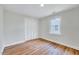 Simple bedroom with hardwood floors, white walls, window and closet at 210 Monk Rd, Durham, NC 27704