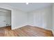 Bedroom featuring hardwood floors, white walls, closet and laundry room doorway at 210 Monk Rd, Durham, NC 27704