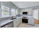 Bright kitchen featuring marble counters, stainless steel appliances, and ample natural light at 210 Monk Rd, Durham, NC 27704