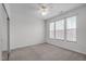 Neutral bedroom featuring a ceiling fan, carpet flooring, and natural light through three windows at 232 Eyam Hall Ln, Apex, NC 27502