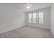 Spacious bedroom with a large window, neutral walls, and soft carpeting at 232 Eyam Hall Ln, Apex, NC 27502