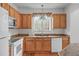 Eat-in kitchen with hardwood floors, oak cabinets, granite countertops, and white appliances at 232 Eyam Hall Ln, Apex, NC 27502