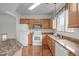Kitchen featuring hardwood floors, oak cabinets, granite countertops, and modern white appliances at 232 Eyam Hall Ln, Apex, NC 27502